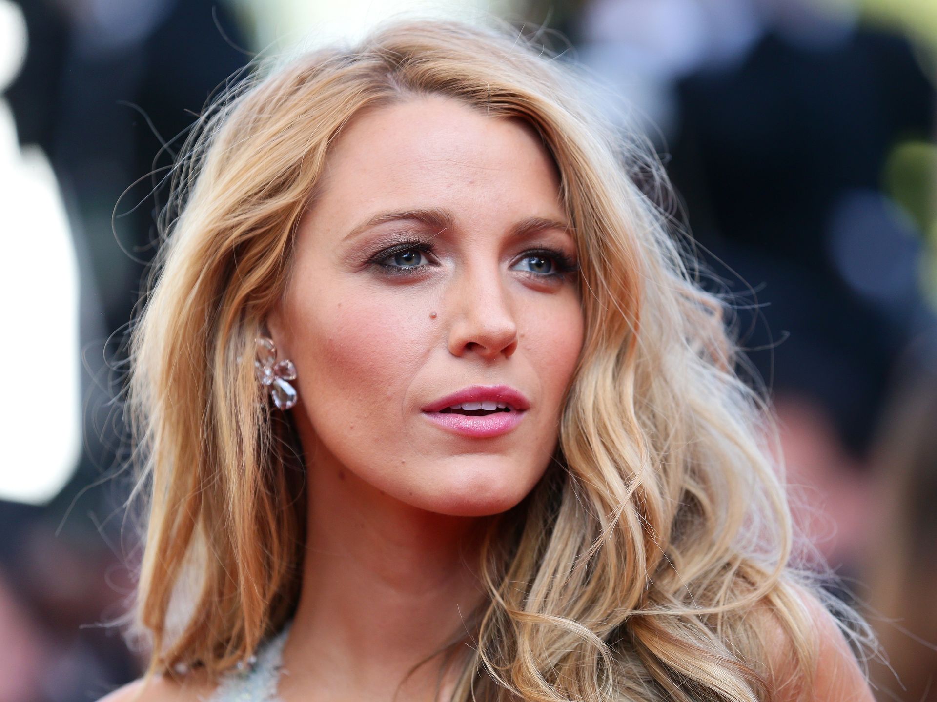 Blake Lively cuts a casual figure in a white crop top and jeans