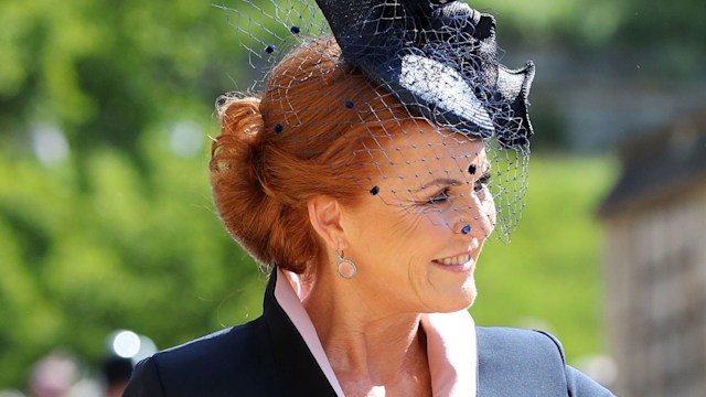 Sarah Ferguson in a black and pink outfit waving at Harry and Meghan's wedding