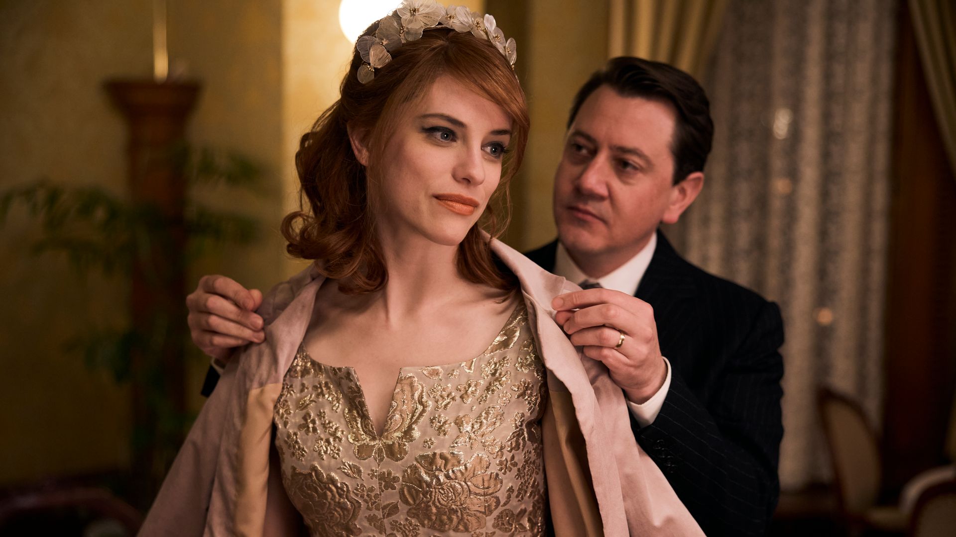 man putting coat on woman