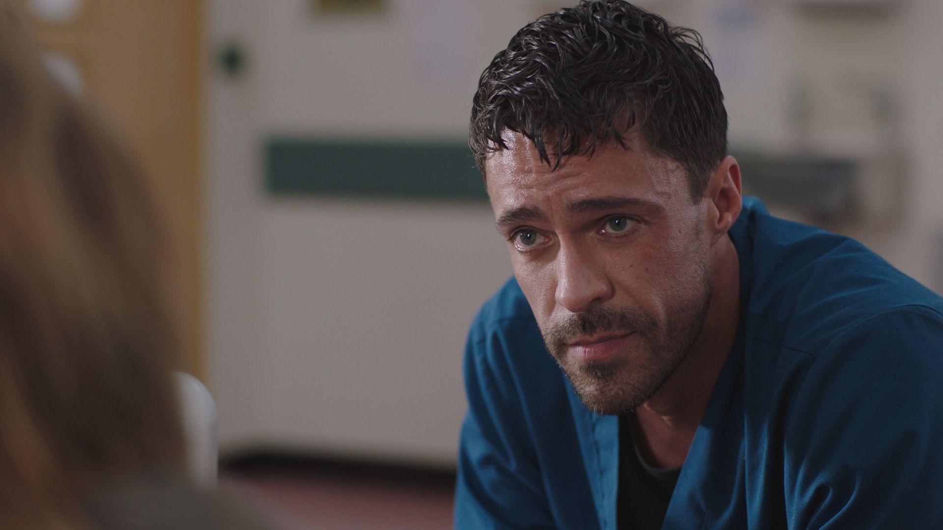 Olly Rix as Flynn Byron crouched down in Casualty
