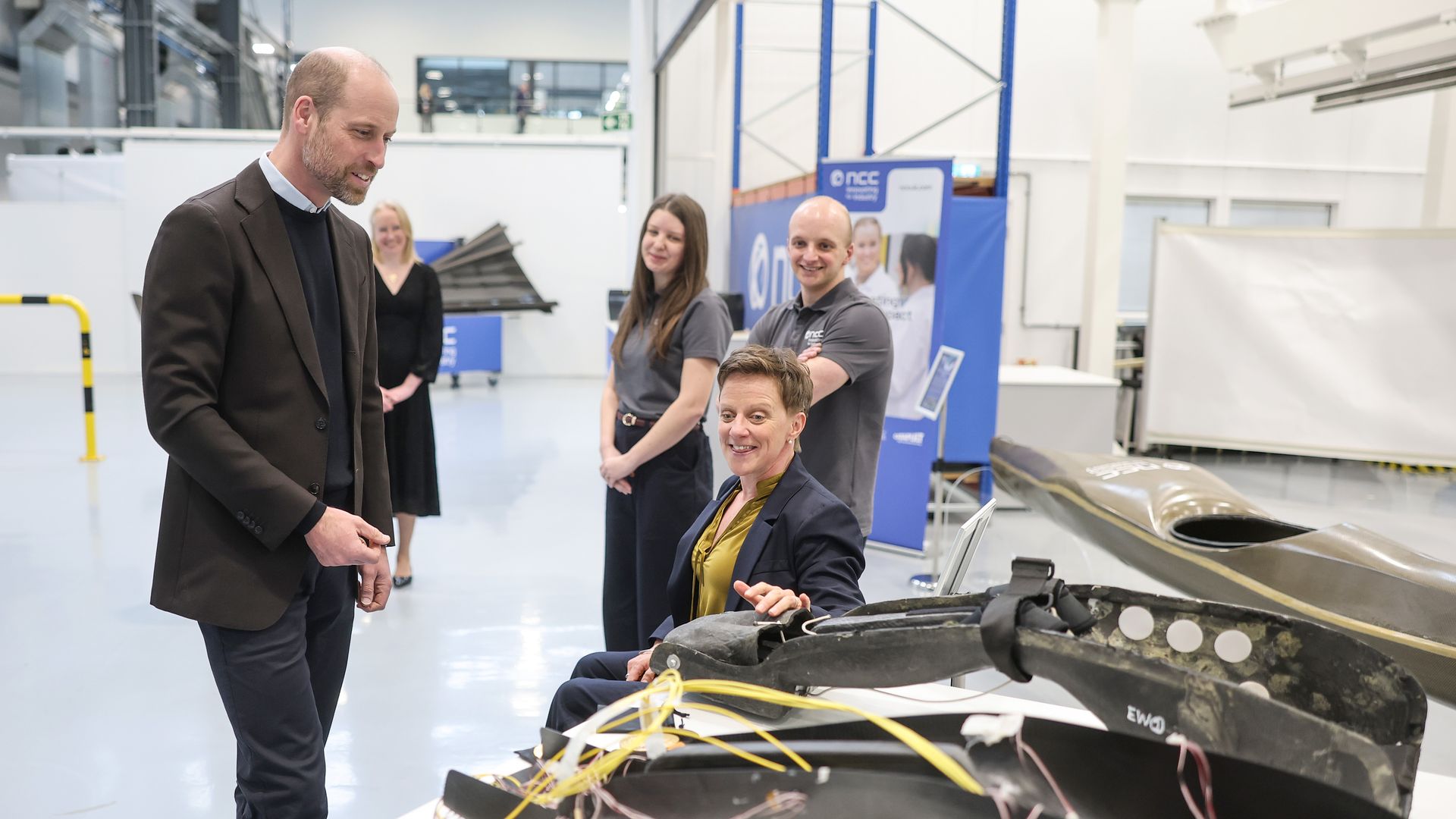 Prince William speaking with Emma Wiggs alongside a paracanoe seat