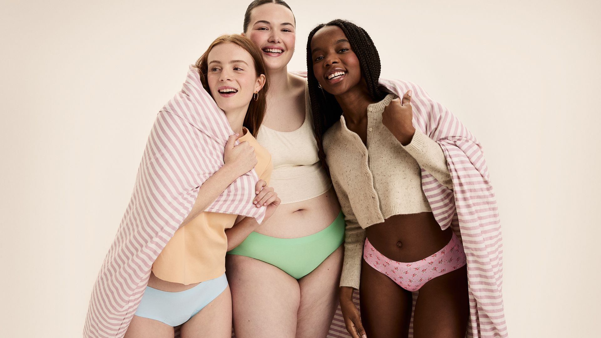 three models stood with arms round each other