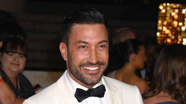 Giovanni Pernice smiling in a white tuxedo