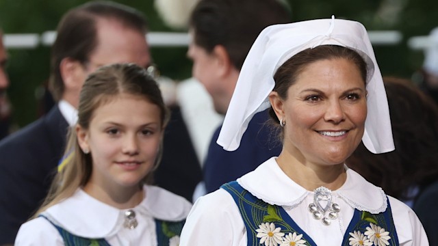 Princess Estelle of Sweden and Crown Princess Victoria of Sweden in national dress smiling