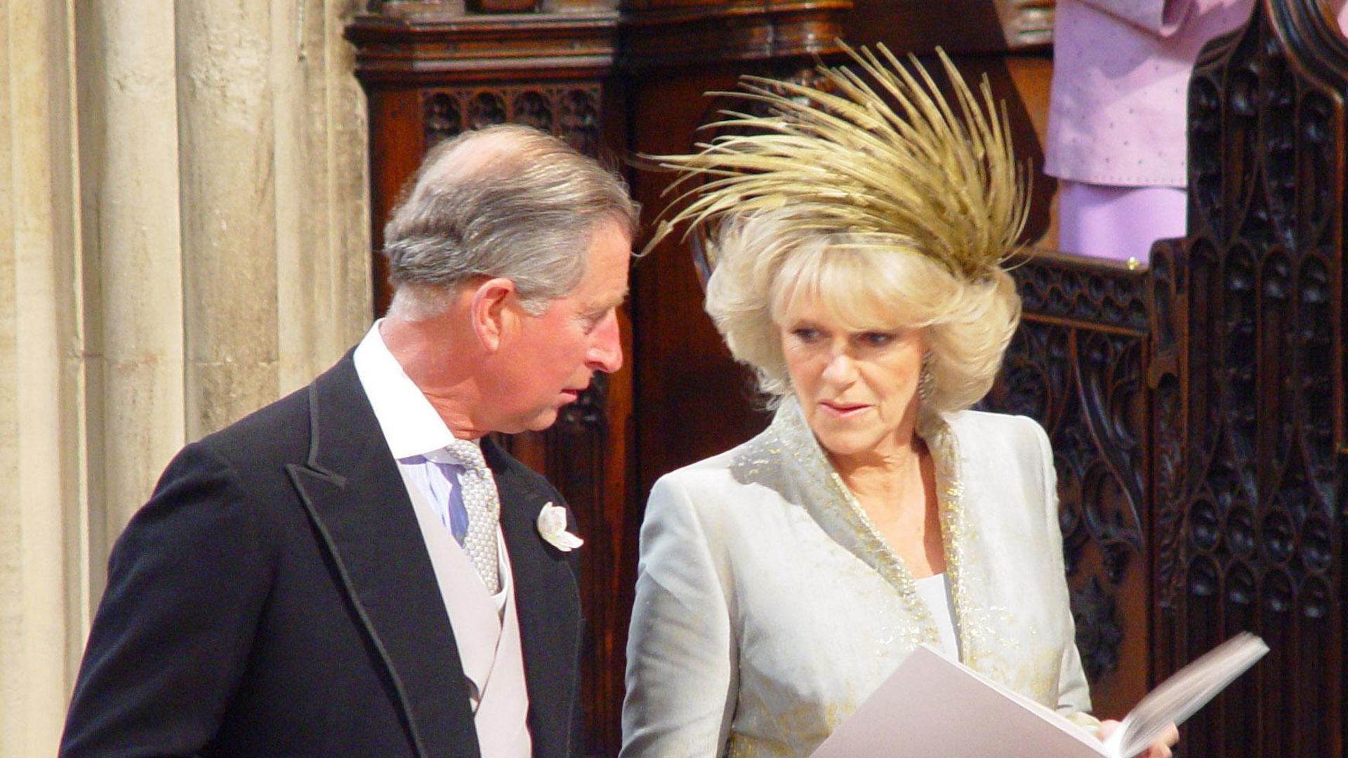 Charles and Camilla holding order of service