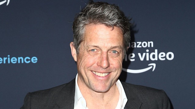 Hugh Grant smiling at a red carpet event