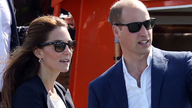 Prince William pointing in sunglasses with Kate Middleton in a blazer