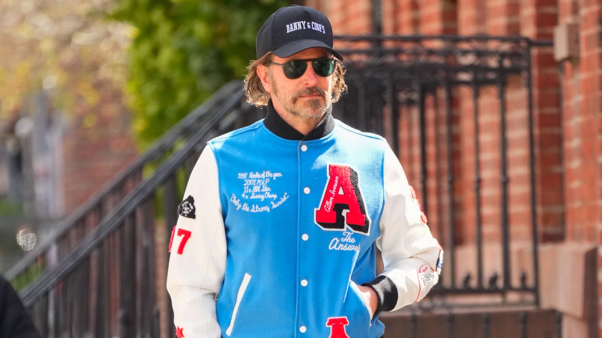 bradley cooper wearing a blue varsity jacket