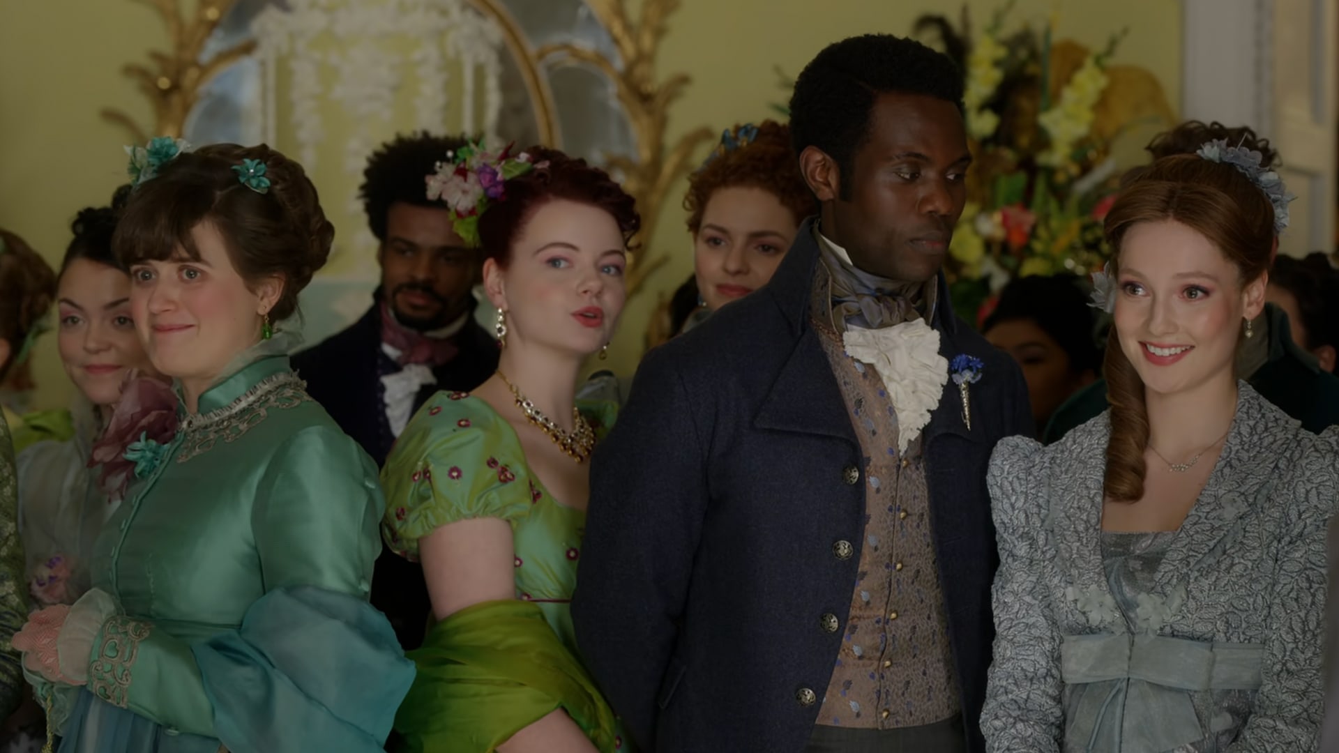 group of people in period clothing standing in ballroom
