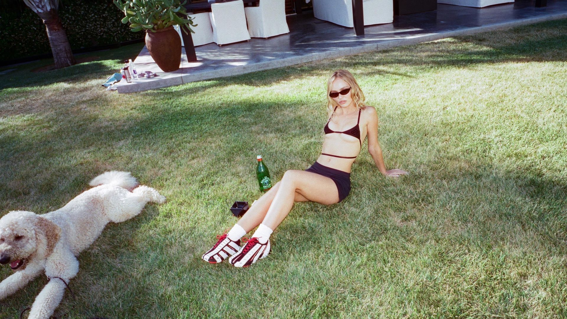 Jocelyn lies on the grass wearing black bra and micro skirt 
