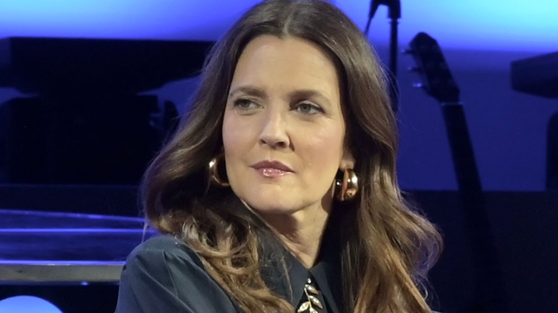 photo of drew barrymore sitting in a chair on stage