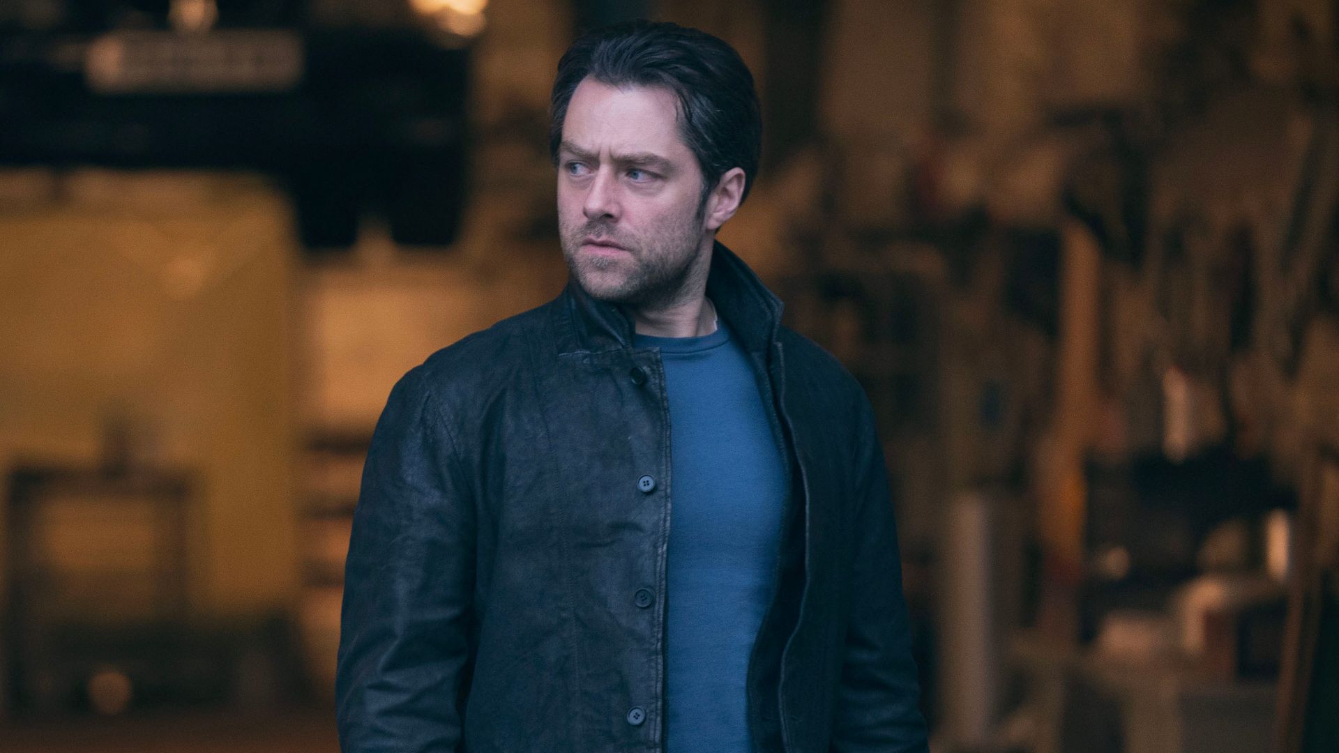 man in dark clothing standing in warehouse