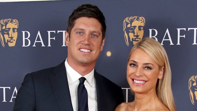 Vernon Kay wearing a blue suit and Tess Daly in a red dress