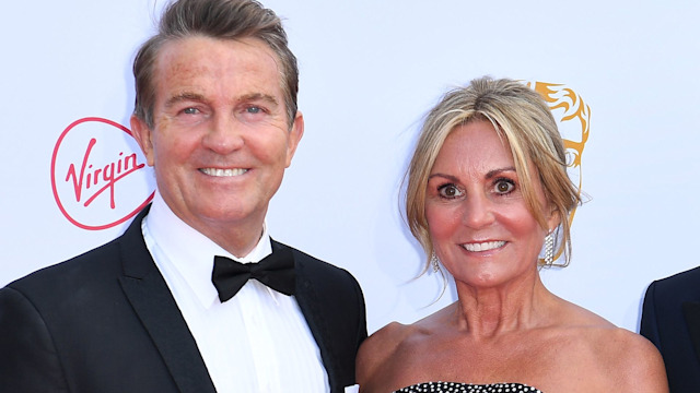 Bradley Walsh in a suit and bow tie with his wife Donna Derby in a black strapless dress