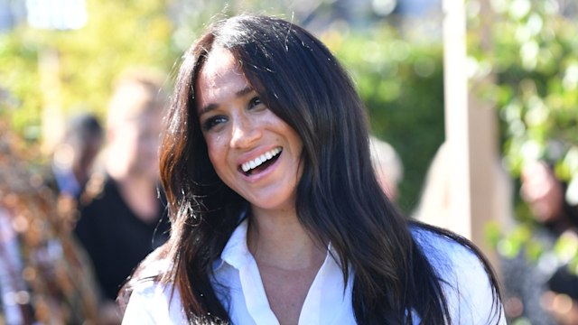 Meghan Markle wearing white shirt and smiling