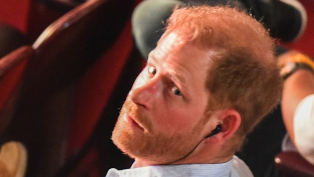 Prince Harry looking over his shoulder in a white shirt