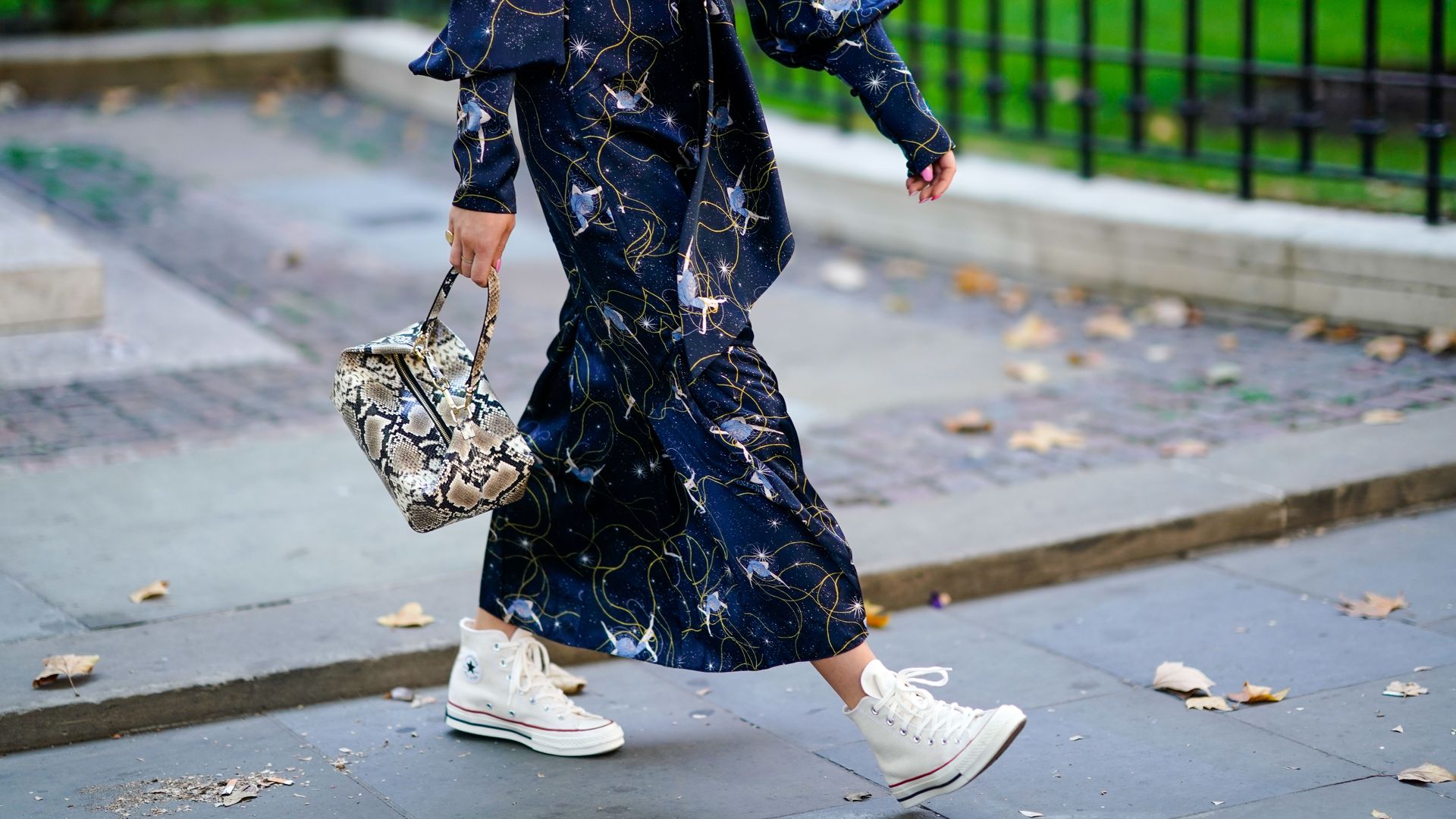 Woman wears printed midi dress with high top trainers 