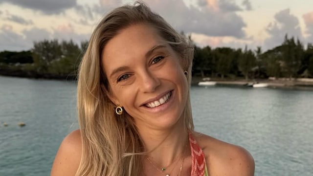 Chelsy Davy smiling on a boat in a printed dress