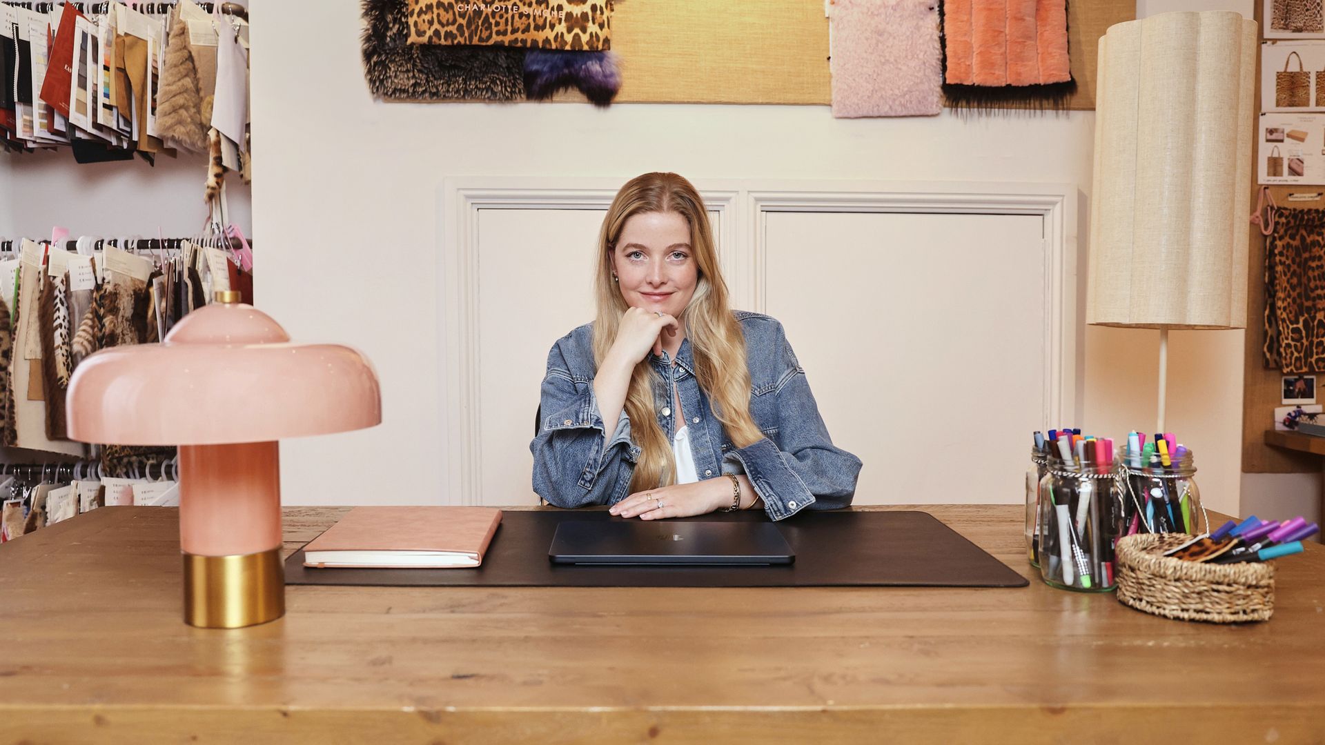 Charlotte Simone sitting behind a desk and posing
