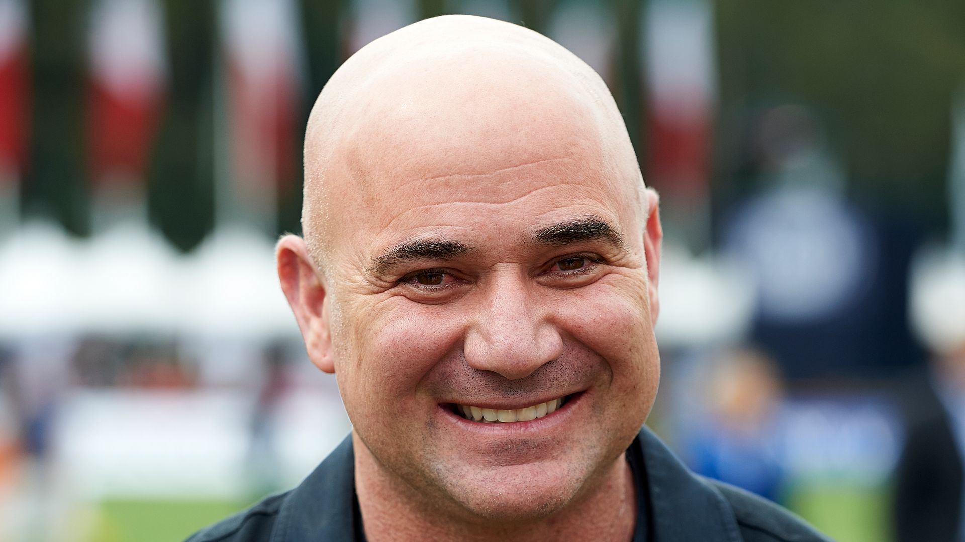 Andre Agassi smiling in black top 