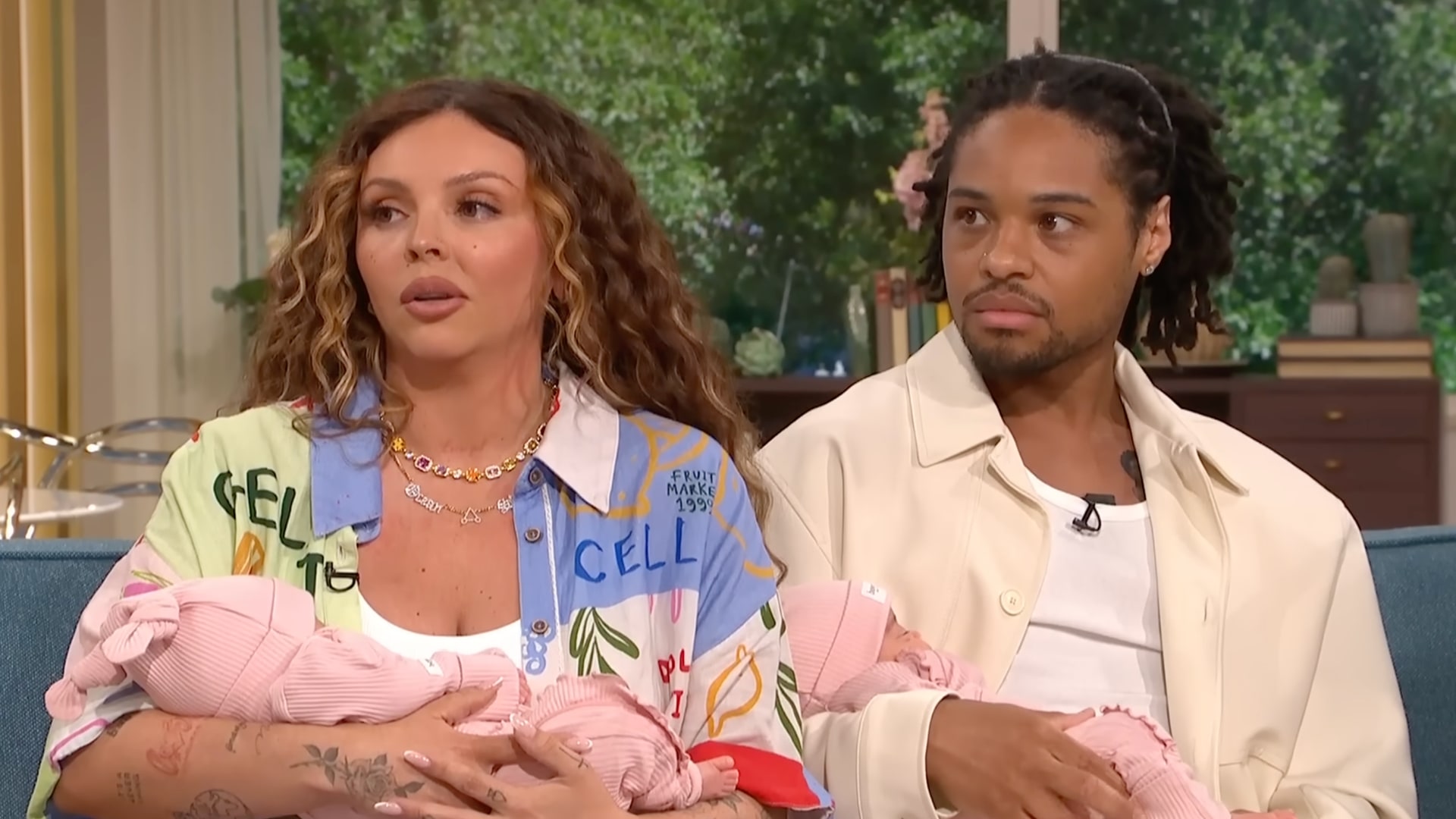 man and woman holding babies in tv studio