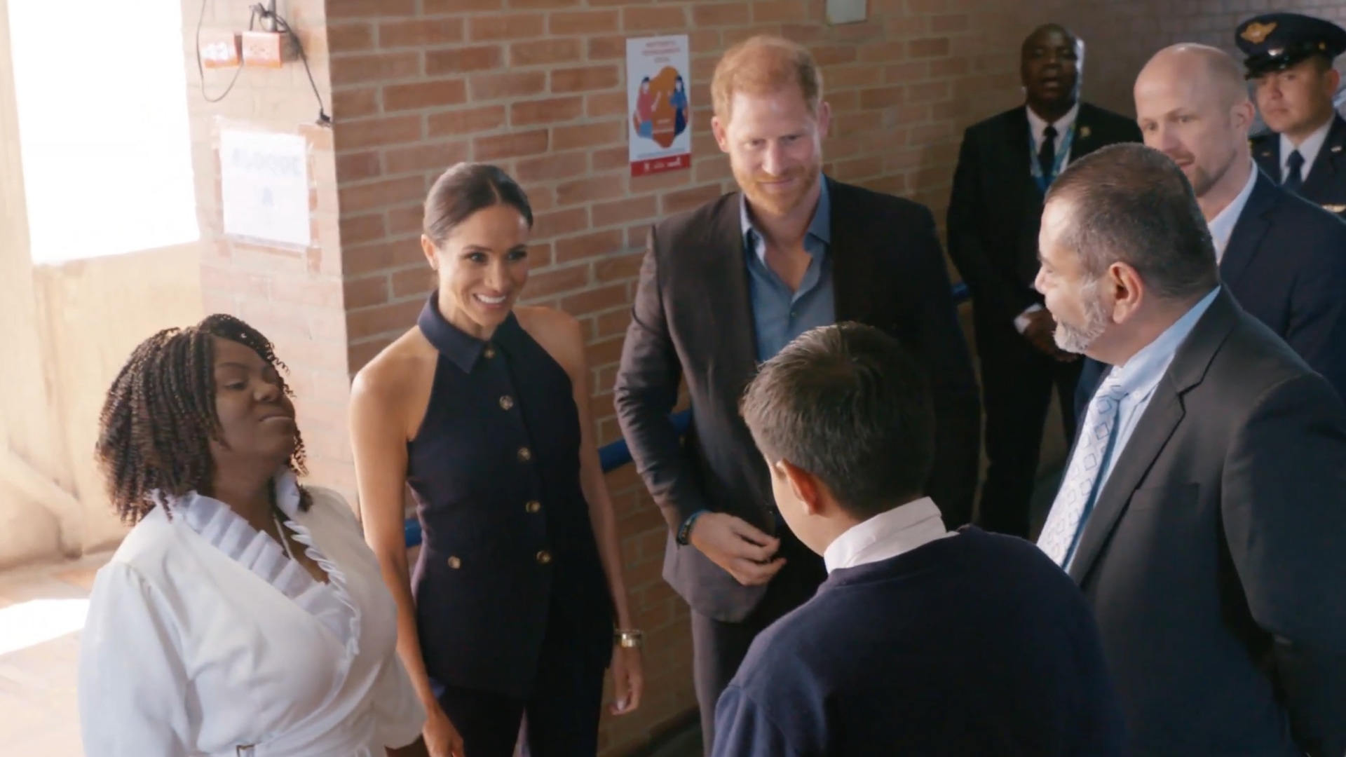 Prince Harry and Meghan Markle speaking to students in a school