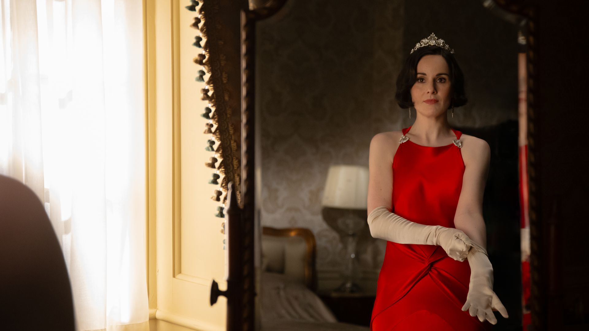 woman in red dress looking in mirror