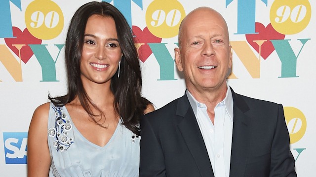 Emma Heming Willis and Bruce Willis smiling which being photo'd at a red carpet event 