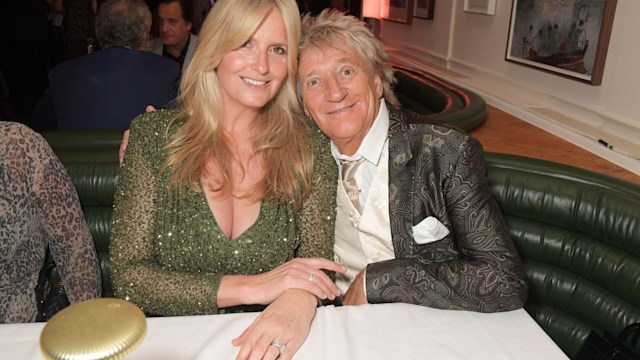 Penny Lancaster and Sir Rod Stewart sitting at table smiling