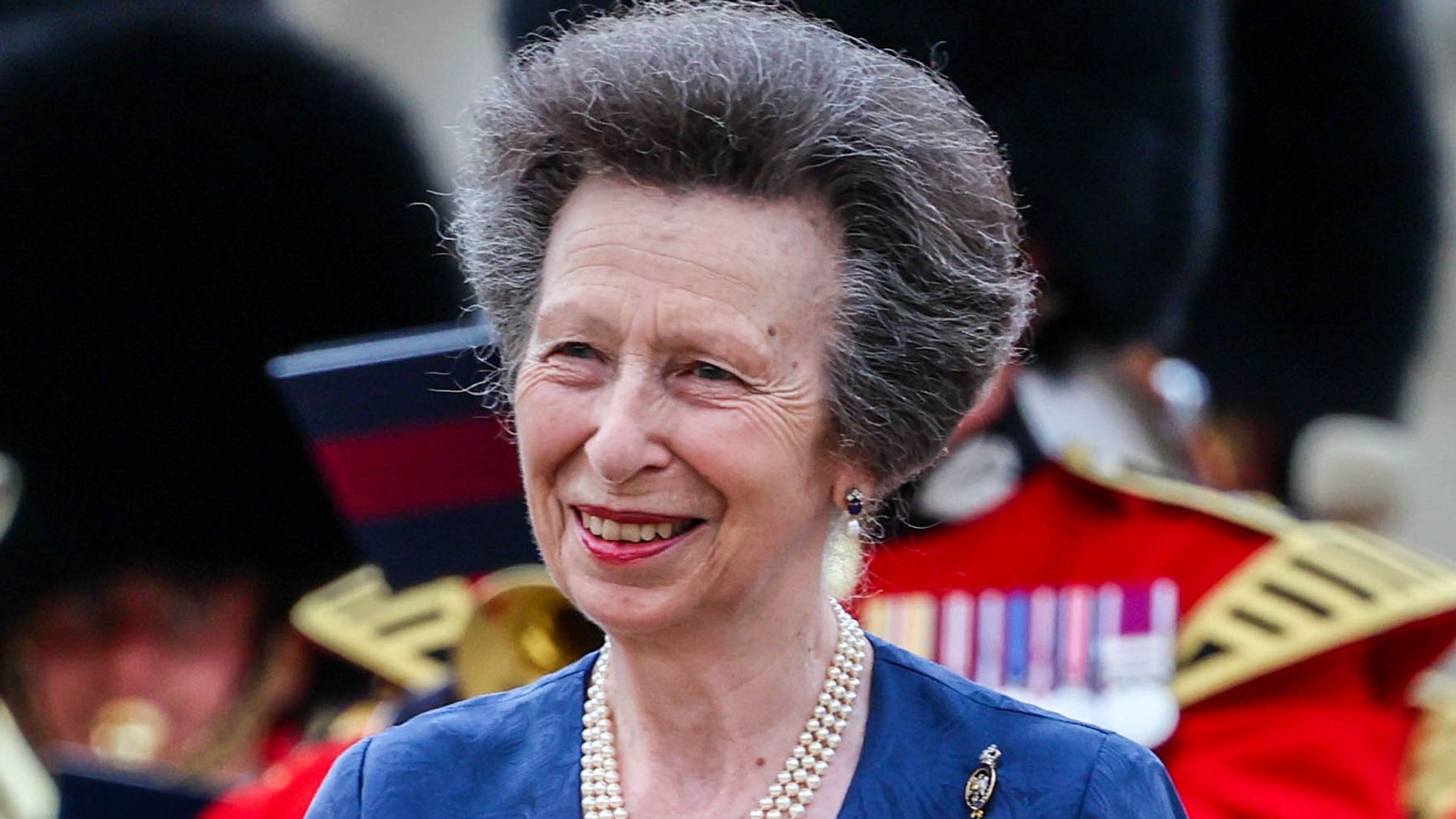 Princess Anne smiling in blue wrap dress