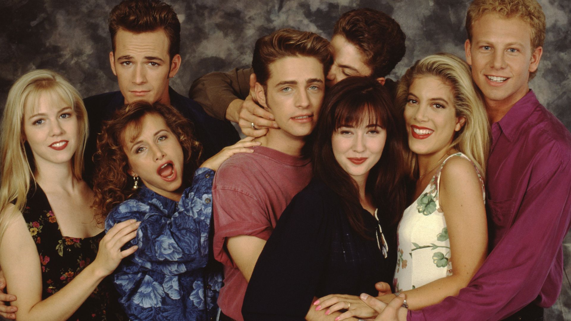 The Beverly Hills, 90210 cast poses for a portrait on set, September 1991 in Los Angeles, California. Left to right: Jennie Garth, Gabrielle Carteris, Luke Perry, Jason Priestley, Brian Austin Green, Shannen Doherty, Tori Spelling and Ian Ziering. 