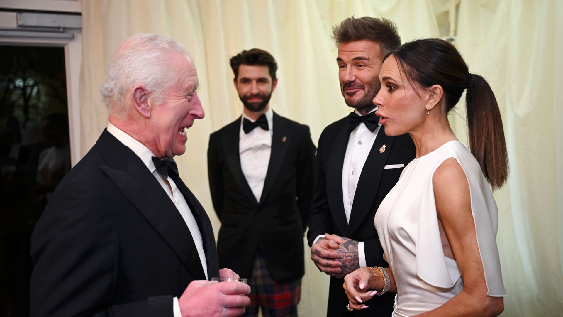 King Charles speaking to David and Victoria Beckham