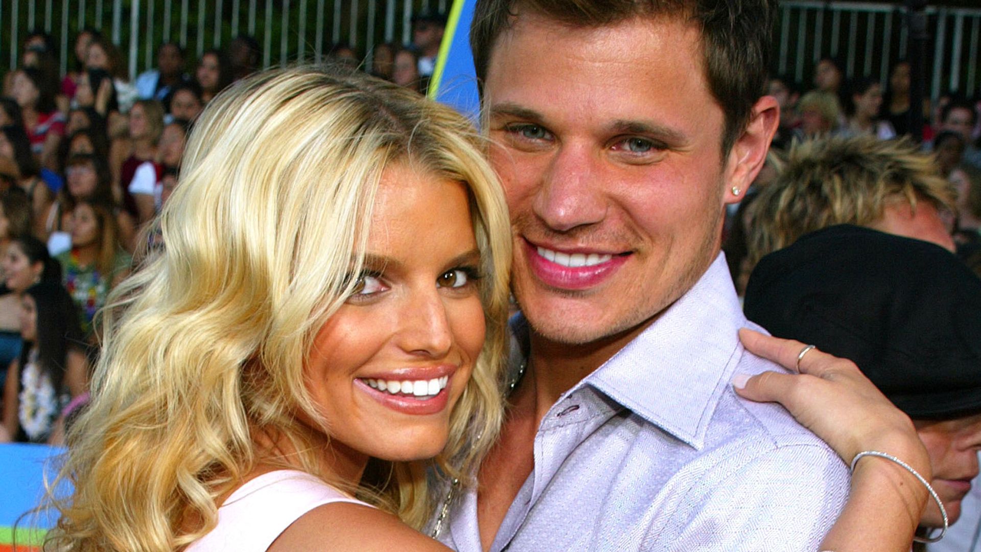 Jessica Simpson and Nick Lachey hug while smiling at the camera
