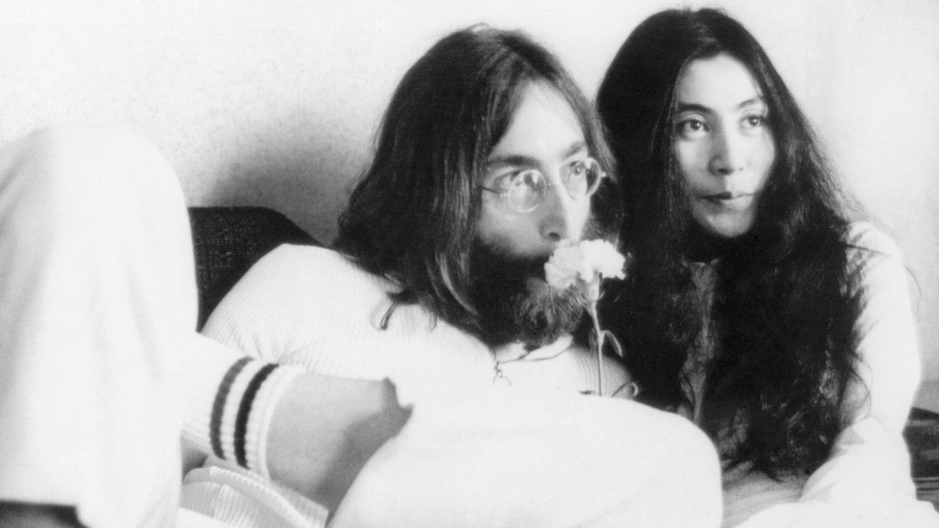 Musician John Lennon and wife Yoko Ono at a press conference from their bed in 1969. The couple announced that they would stay in bed seven days "to conceive a baby in Amsterdam" and called it "a make-love-and-not-war-protest, a happening, a bed production."