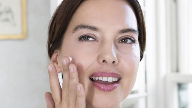 woman moisturising face