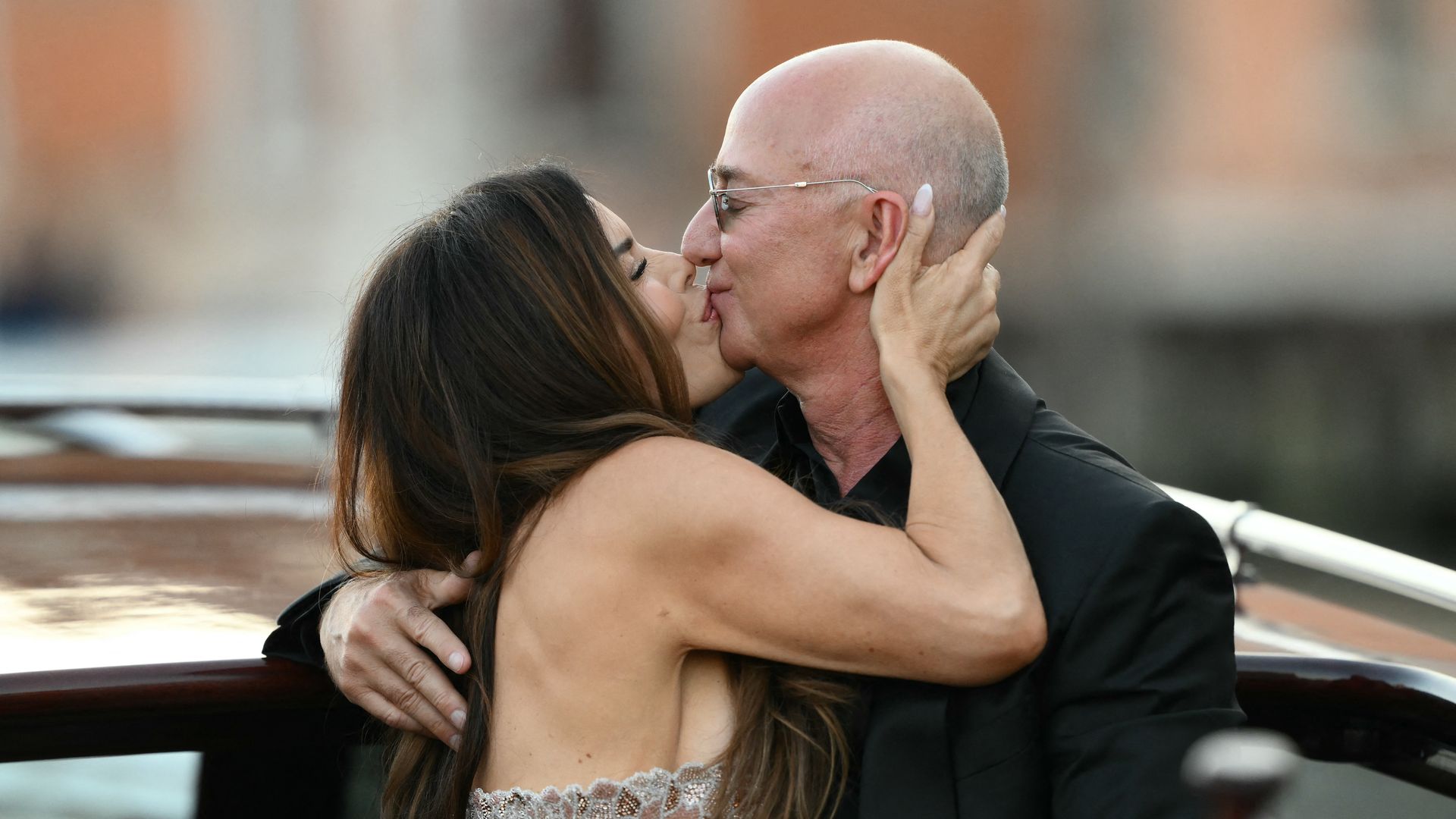 Amazon's founder Jeff Bezos and spouse Lauren Sanchez Bezos kiss as they leave the Aman Hotel on the third day of their wedding festivities, in Venice on June 28, 2025