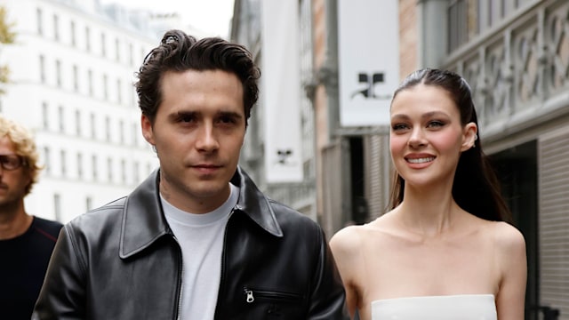 Brooklyn Beckham wears white t-shirt, black CourrÃ¨ges leather jacket, matching pants, black boots, and Nicola Peltz wears white jumpsuit with sheer details, white CourrÃ¨ges bag, outside CourrÃ¨ges,  during Womenswear Spring/Summer 2025 as part of  Paris Fashion Week on September 25, 2024 in Paris, France. (Photo by Claudio Lavenia/Getty Images)