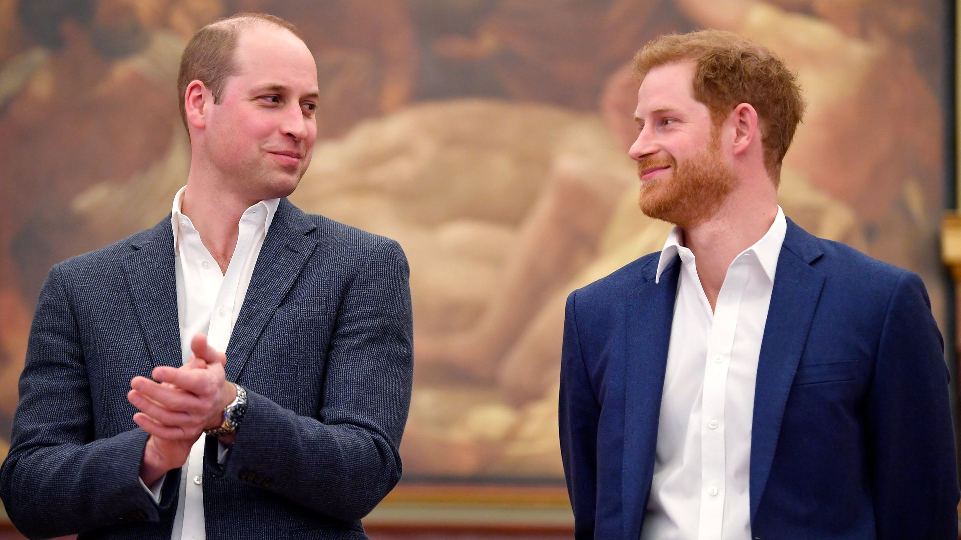 Prince William and Prince Harry smirking at each other