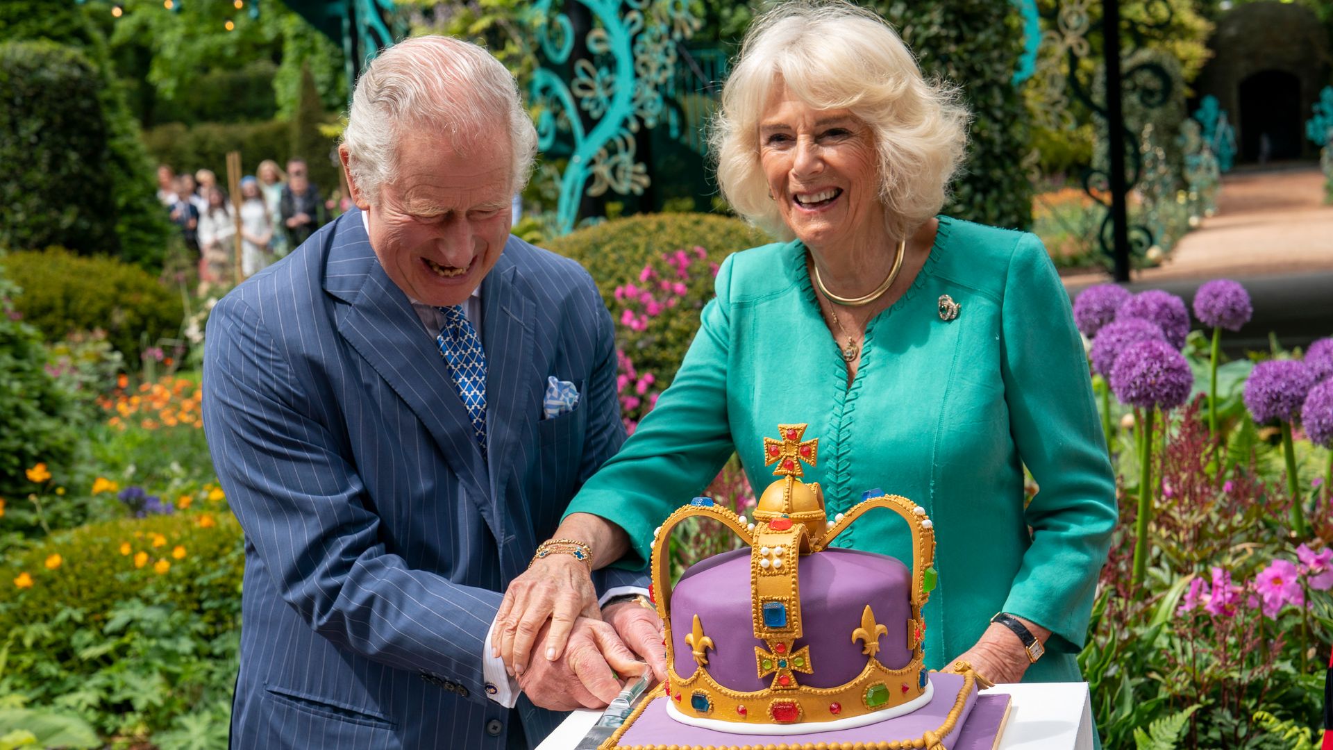 King Charles III and Queen Camilla cut a cake during a visit to open the new Coronation Garden on day one of their two-day visit to Northern Ireland on May 24, 2023 in Newtownabbey, Northern Ireland. 