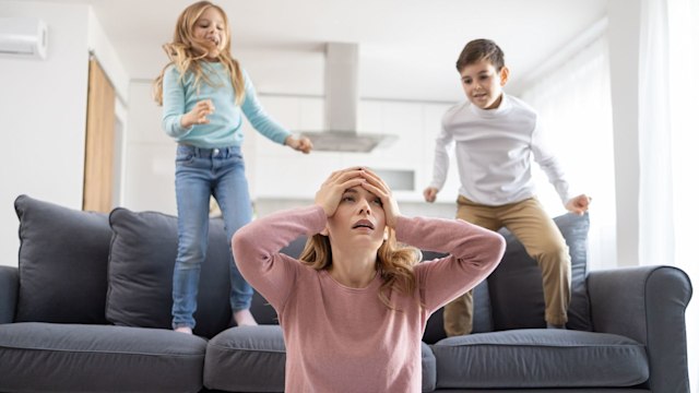 Overwhelmed mother with playful kids