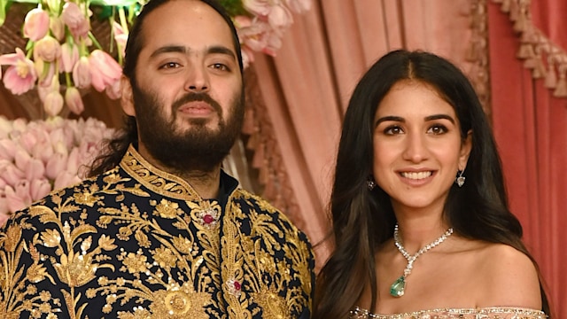 Anant Ambani in a gold jacket with Radhika Merchant in an off the shoulder top