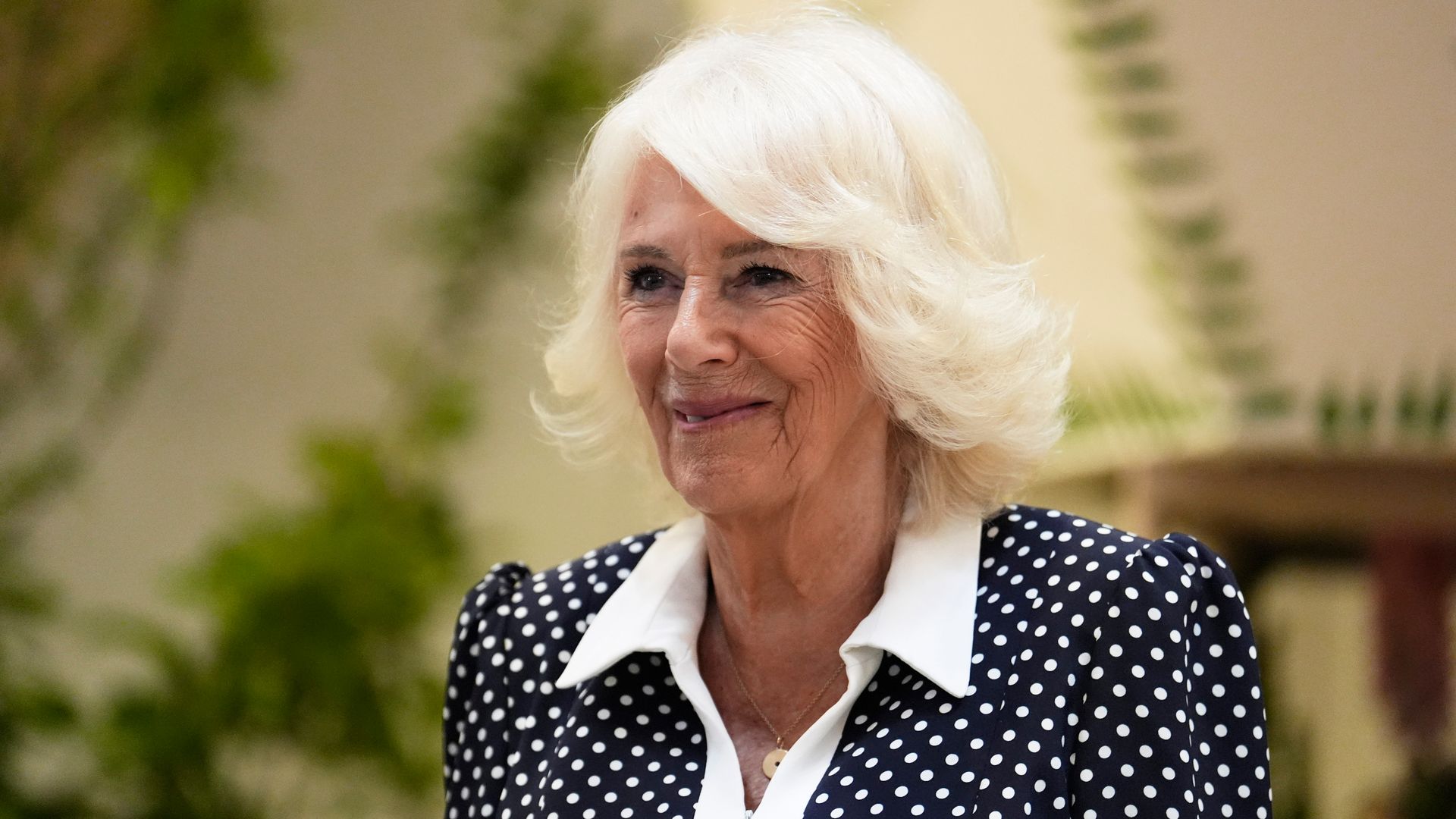 Queen Camilla smiling in polka dot dress