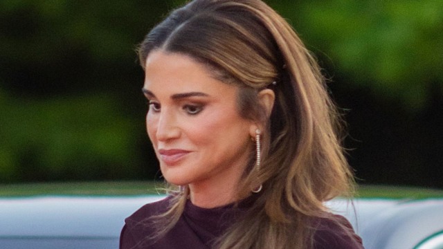 Queen Rania walking next to a car with curled hair