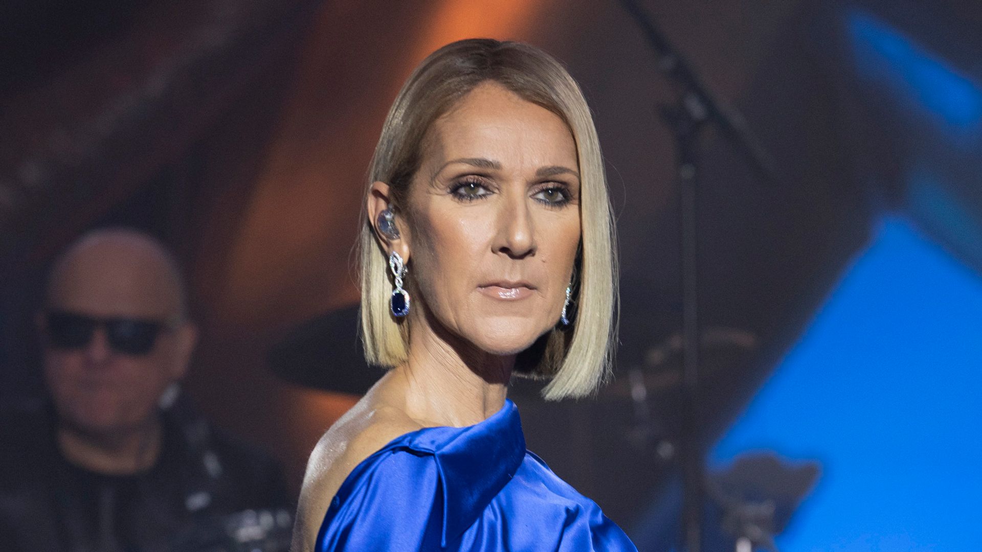 Celine Dion looking serious in a blue dress