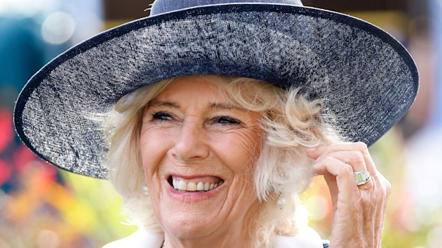 queen camilla smiling in blue hat