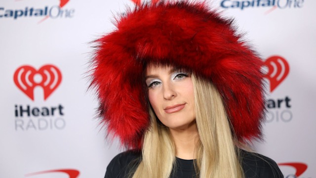 Meghan Trainor in a fluffy red hat on the red carpet 