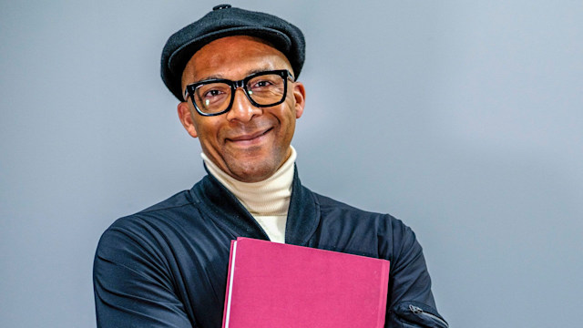 Jay Blades holding a book and smiling