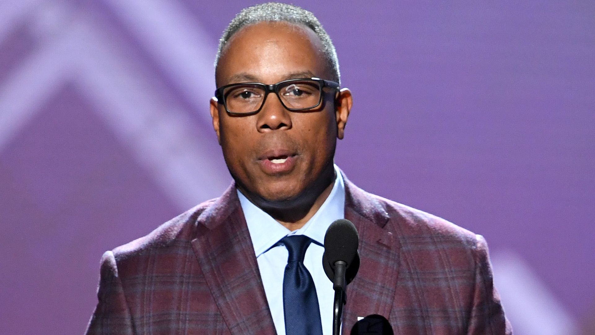 Jay Harris talks into mic looks serious