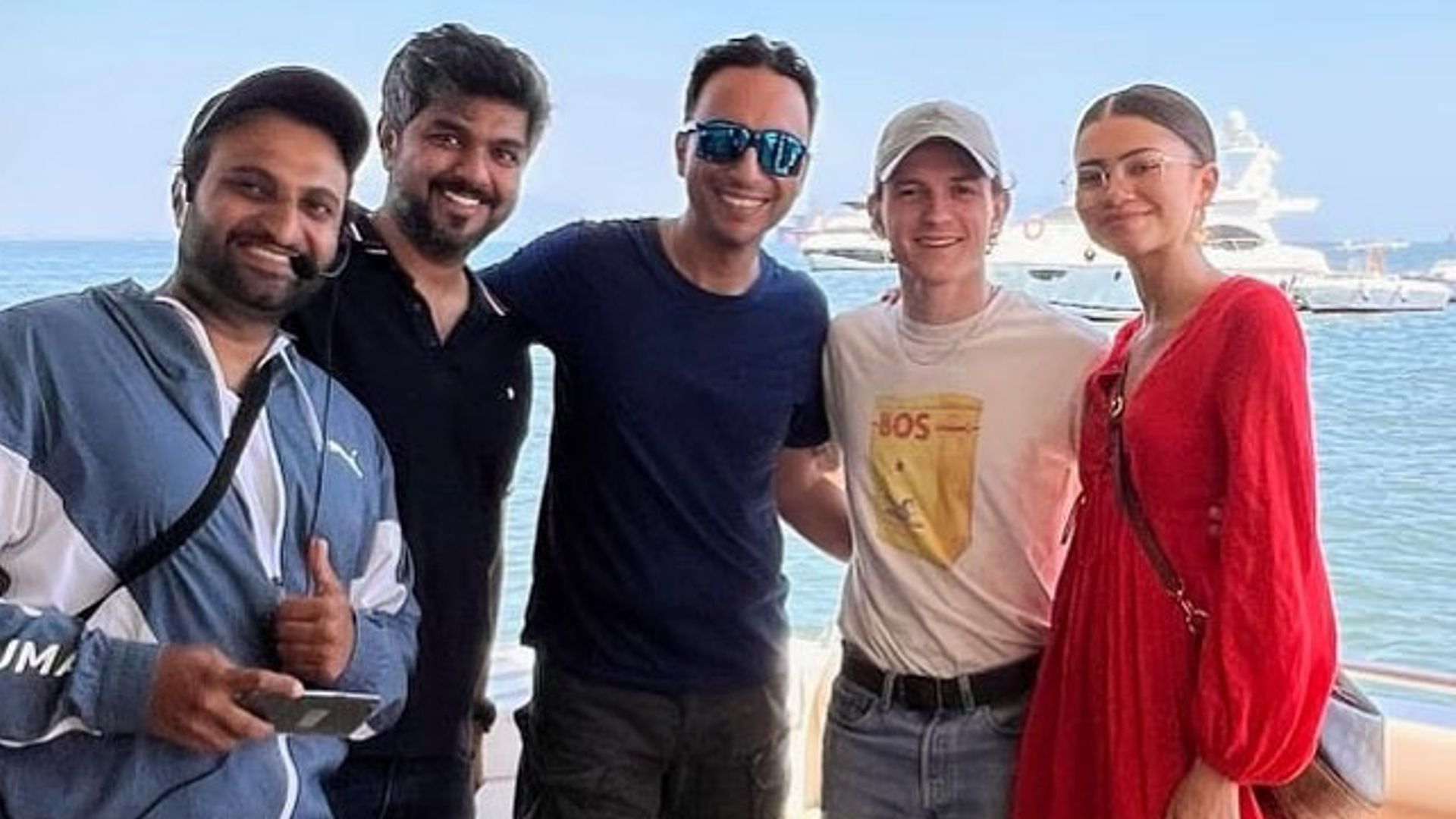 Tom and Zendaya posing with three of the yacht team to their left
