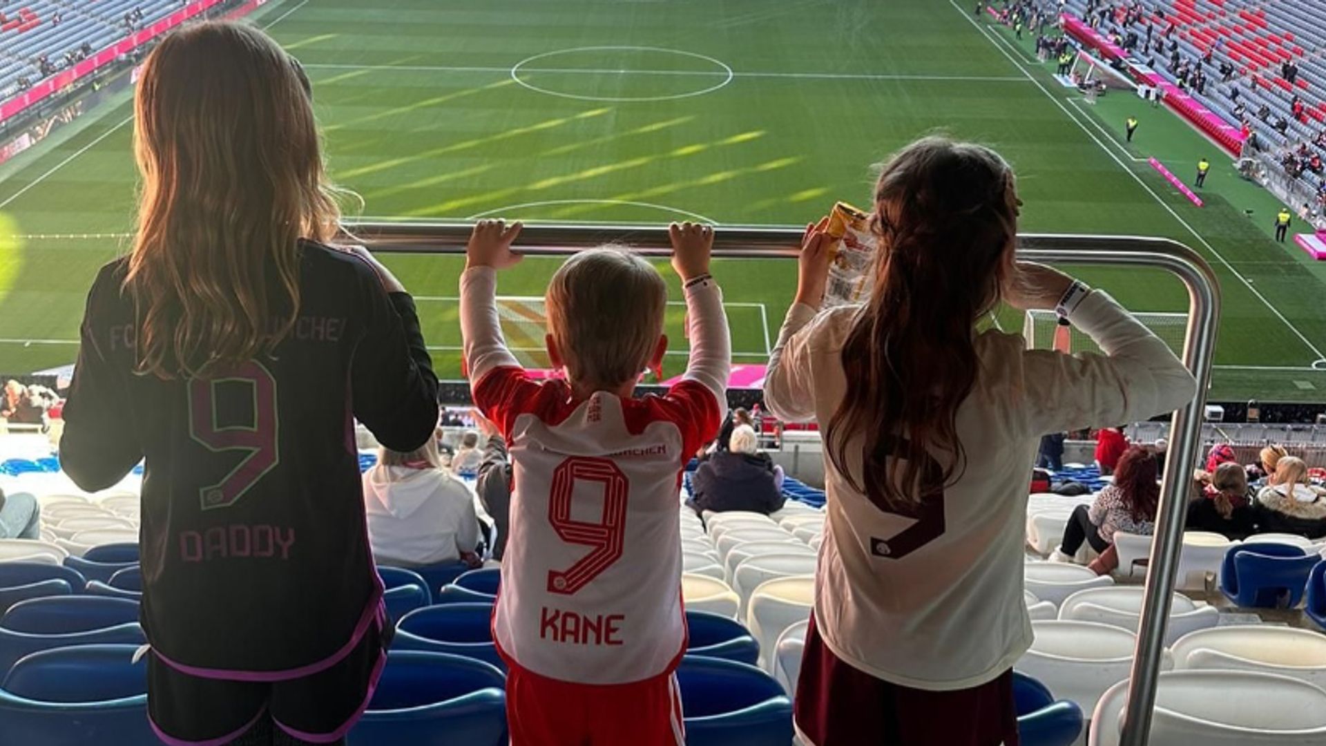 Three children looking at a football pitch